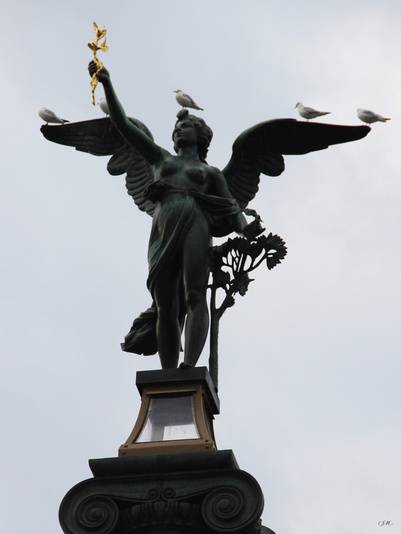 pássaros pousados em uma estátua